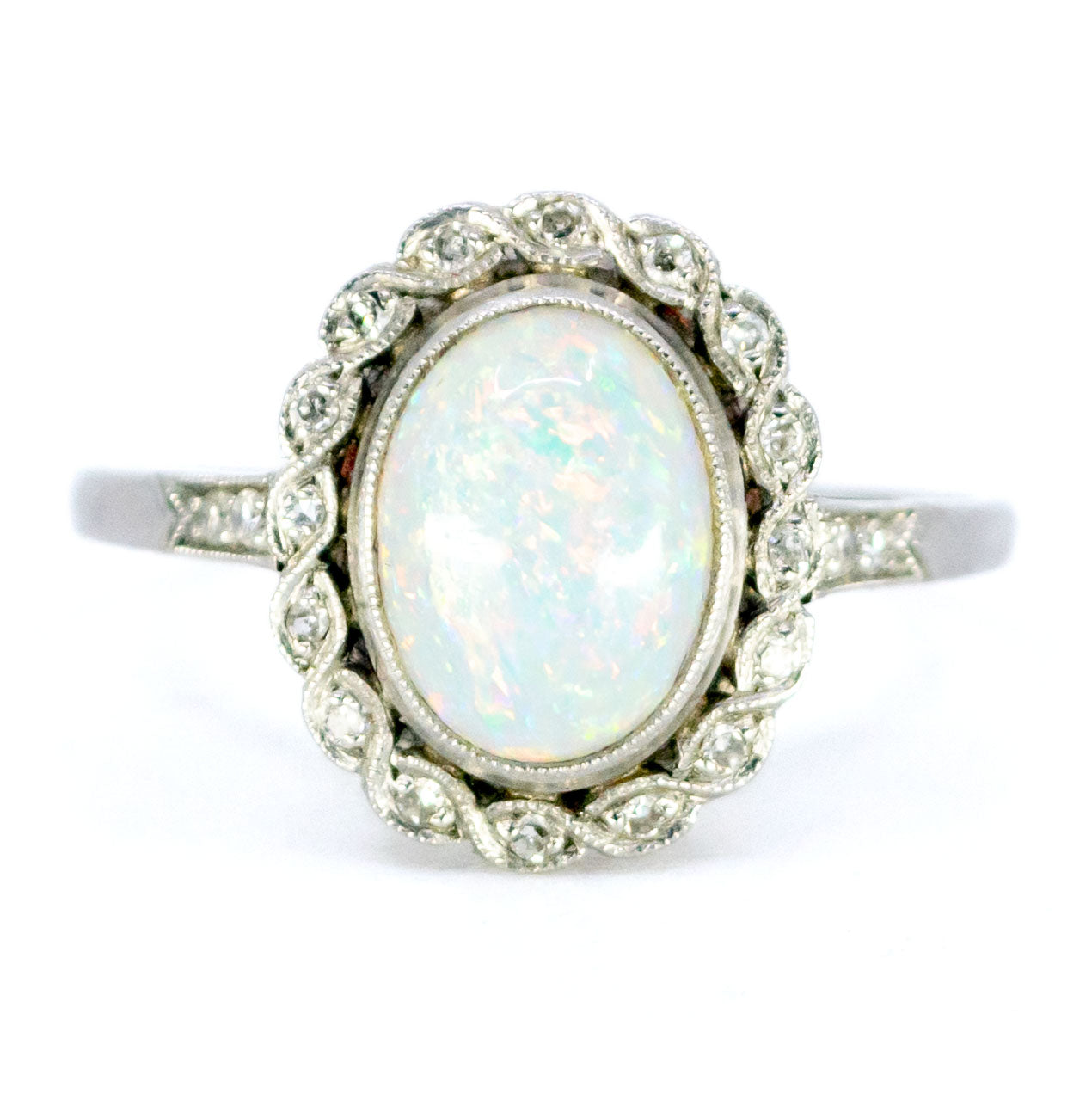 An oval opal and diamond cluster ring in platinum