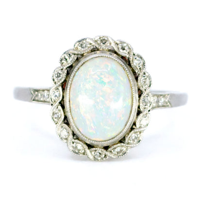 An oval opal and diamond cluster ring in platinum
