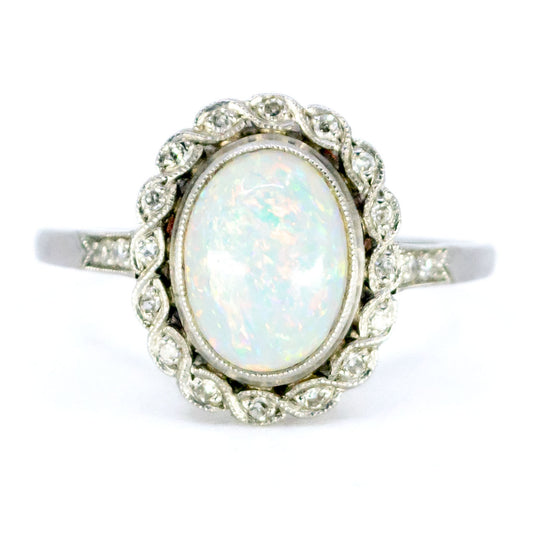 An oval opal and diamond cluster ring in platinum