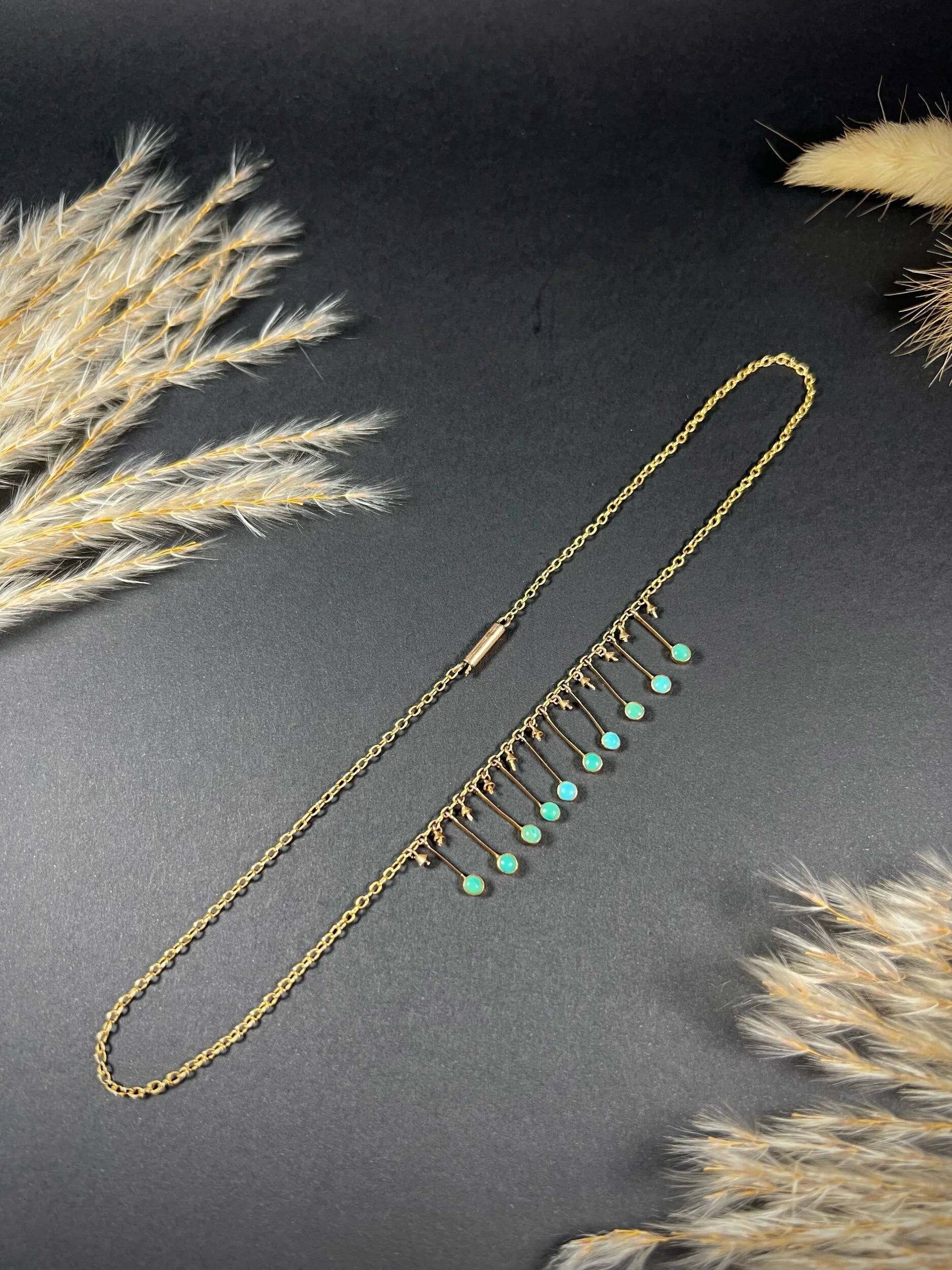 A gold negligee pendant necklace with turquoise drops