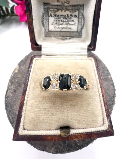 A seven stone sapphire and diamond carved ring in yellow gold, in a ring box