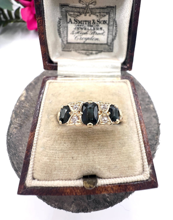 A seven stone sapphire and diamond carved ring in yellow gold, in a ring box