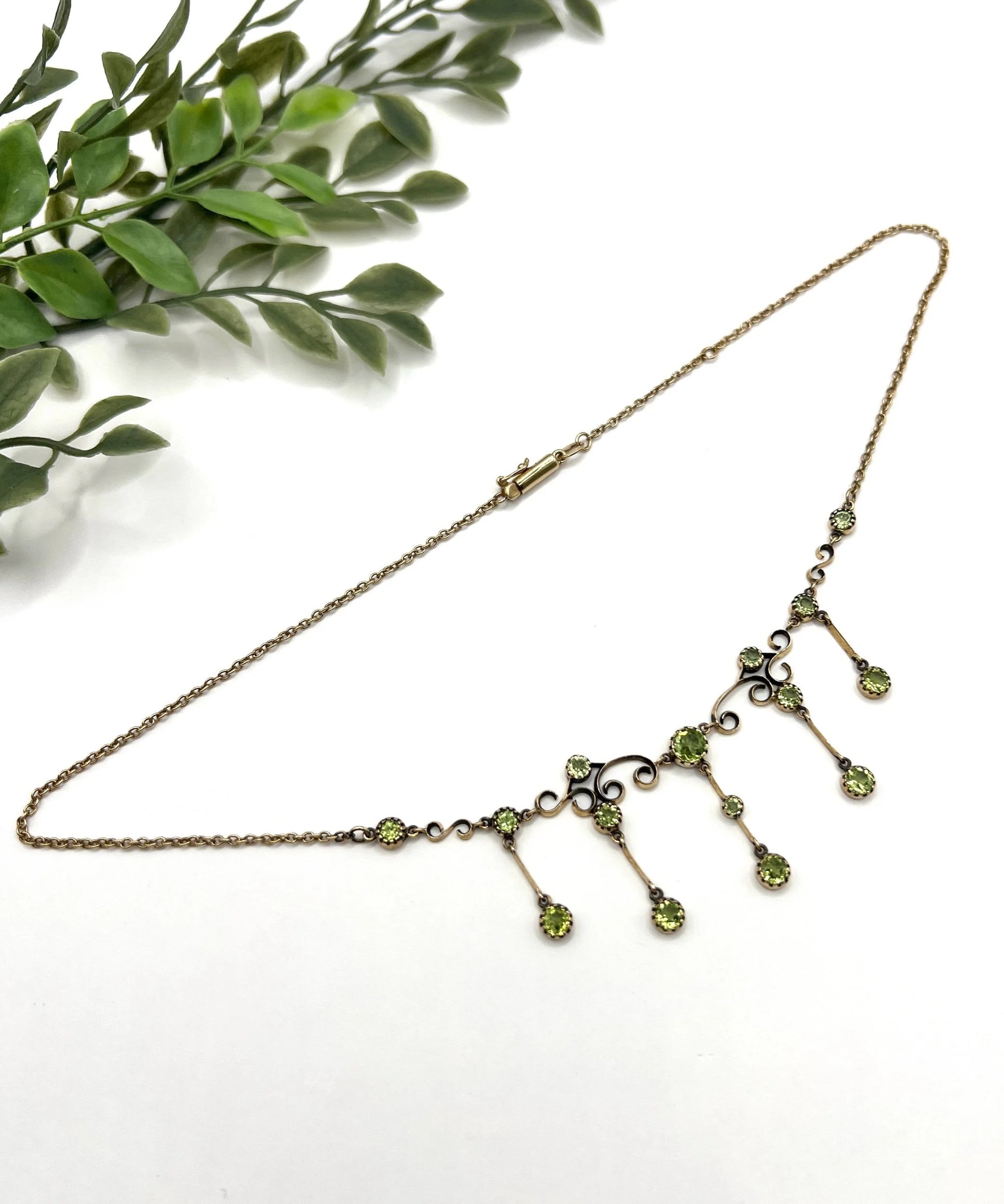 A yellow gold swag necklace with peridot drops