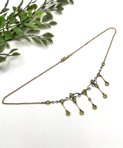 A yellow gold swag necklace with peridot drops