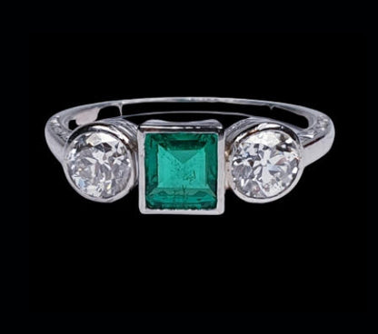 Princess Cut Colombian Emerald and Diamond Three Stone Ring; central 0.50 carats modified square-cut emerald of intense colour set in-between two old European transitional cut diamonds totalling 0.66 carats, in platinum