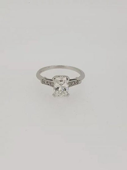 Emerald Cut Diamond Solitaire Engagement Ring; central 1.18 carat emerald-cut diamond, four-claw-set, accented with diamond set shoulders, in 18ct white gold