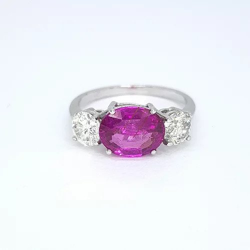 Pink Sapphire and Diamond Three Stone Ring; 2.30ct oval cut pink sapphire flanked by 0.97cts brilliant cut diamonds, in 18ct white gold