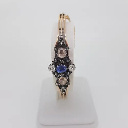 Antique Victorian Natural Sapphire and Old Cut Diamond Bangle Bracelet; central oval faceted natural sapphire surrounded by two white old-cut diamonds and two foiled pink rose-cut diamonds. Decorated with smaller rose cut diamonds