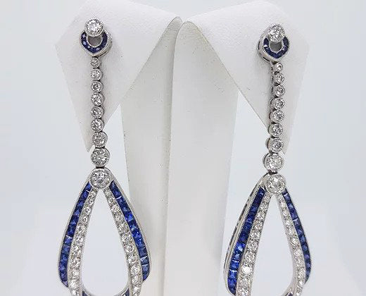 Pair of Contemporary Sapphire, Diamond and Platinum Drop Earrings; featuring calibre-cut sapphires and brilliant-cut diamonds.