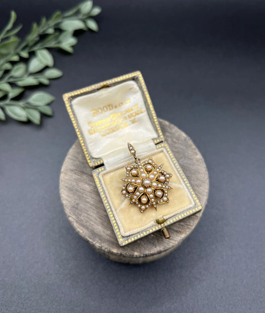 A yellow gold brooch/pendant with pearls in the shape of a star, in an antique box