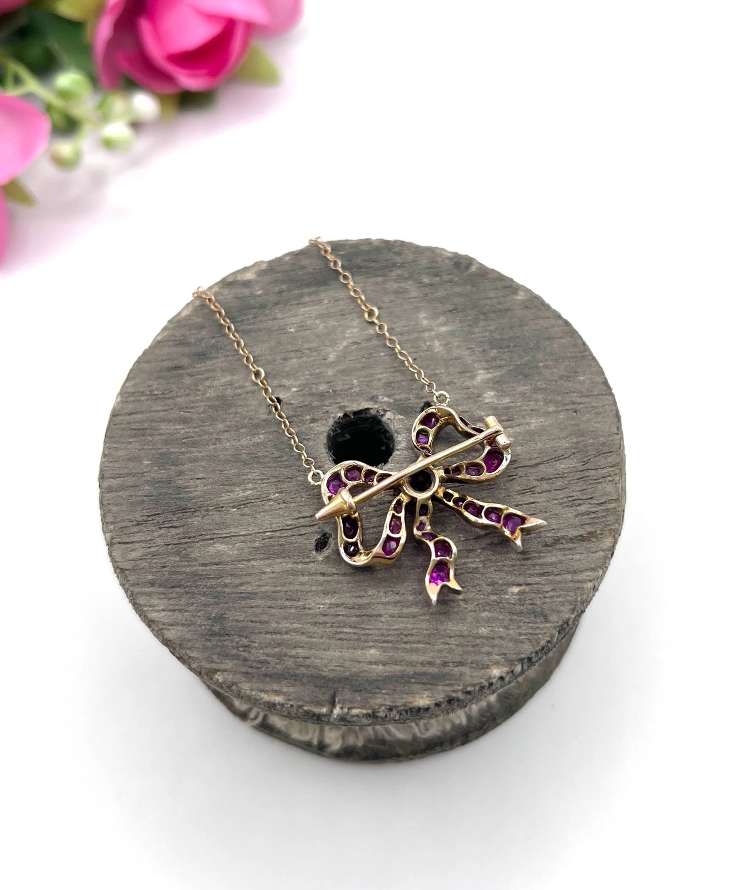 A ruby bow brooch necklace in gold and silver