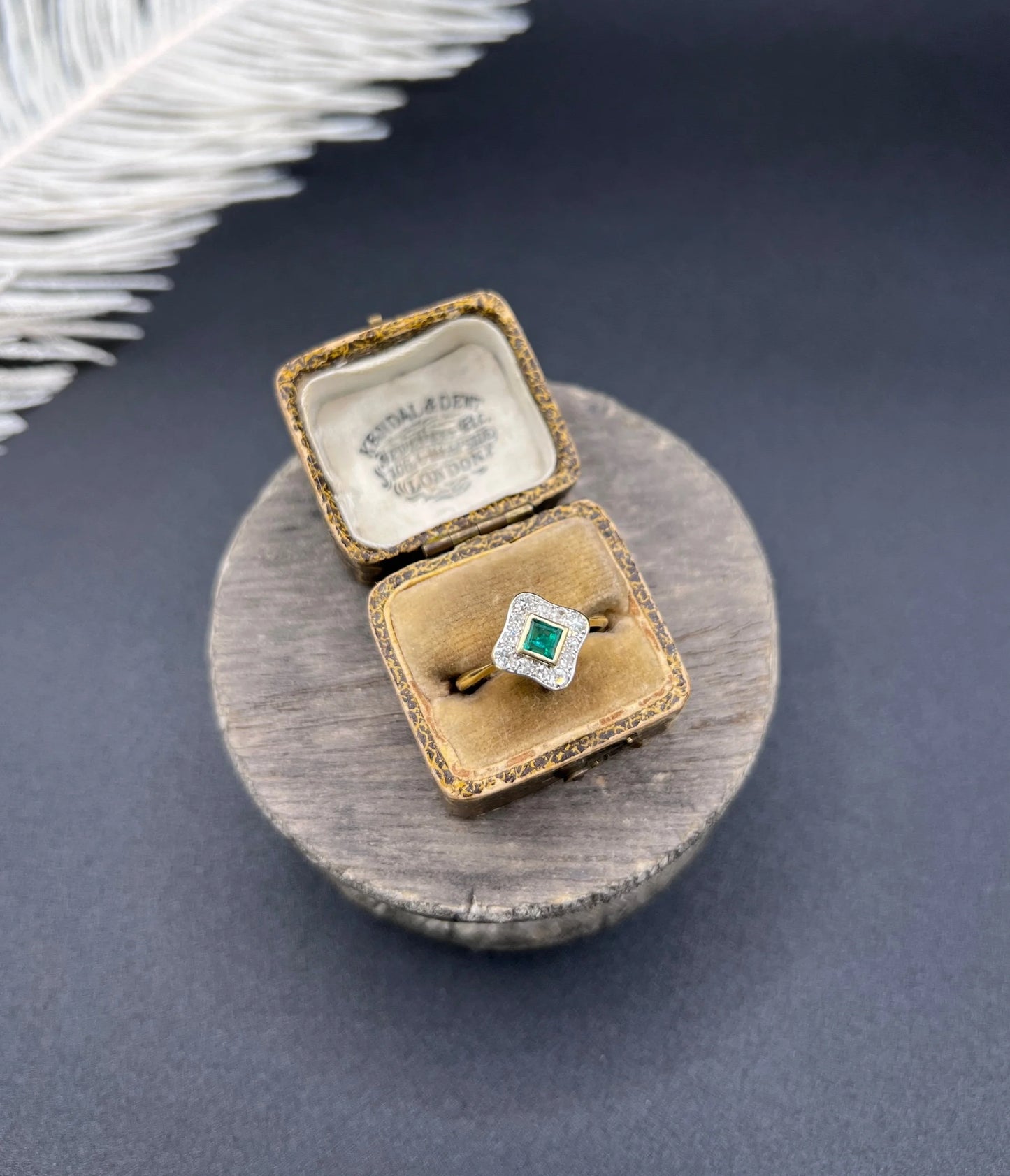 An emerald and diamond cluster ring in yellow gold and platinum, in an antique ring box