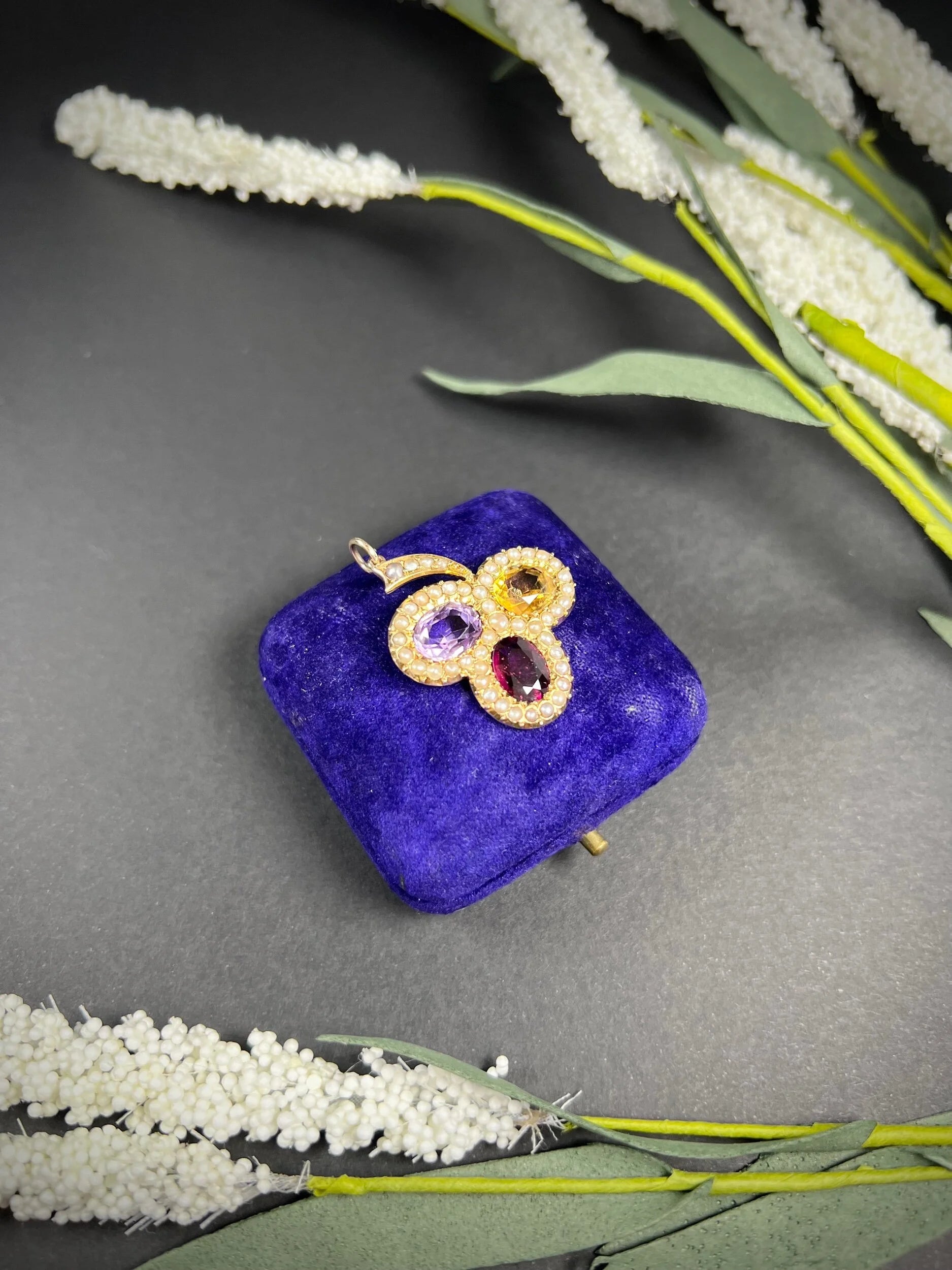 A yellow gold clover pendant with amethyst, citrine, garnet and seed pearls