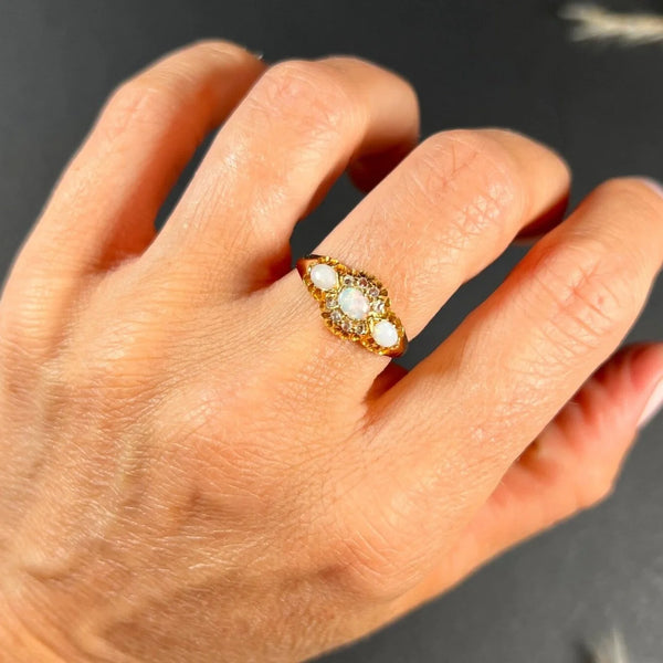 A yellow gold opal and diamond dress ring, modelled on a hand