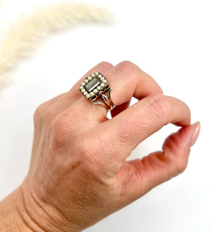 An antique seed pearl mourning ring in gold, modelled on a hand