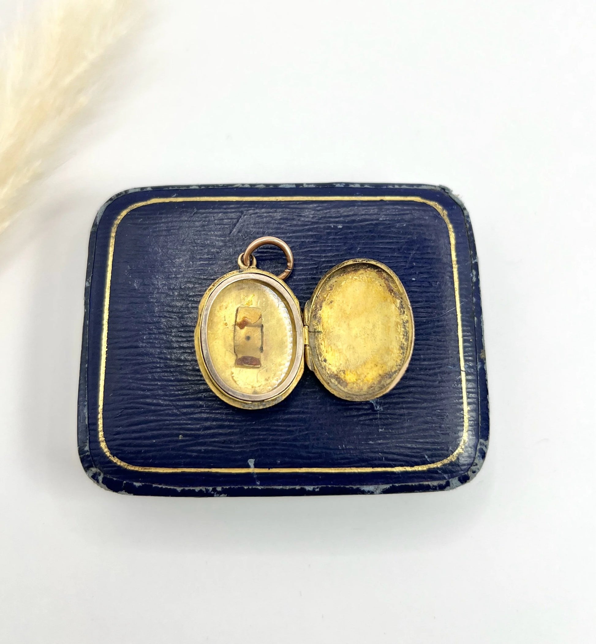 An oval yellow gold locket, open