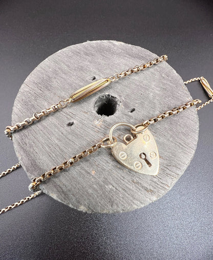 A yellow gold fancy link chain with a heart padlock