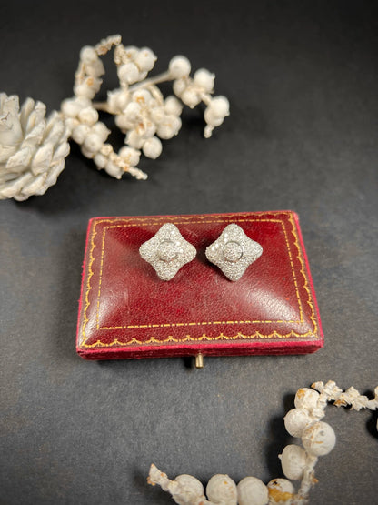 A pair of diamond cluster stud earrings in white gold, on an antique box