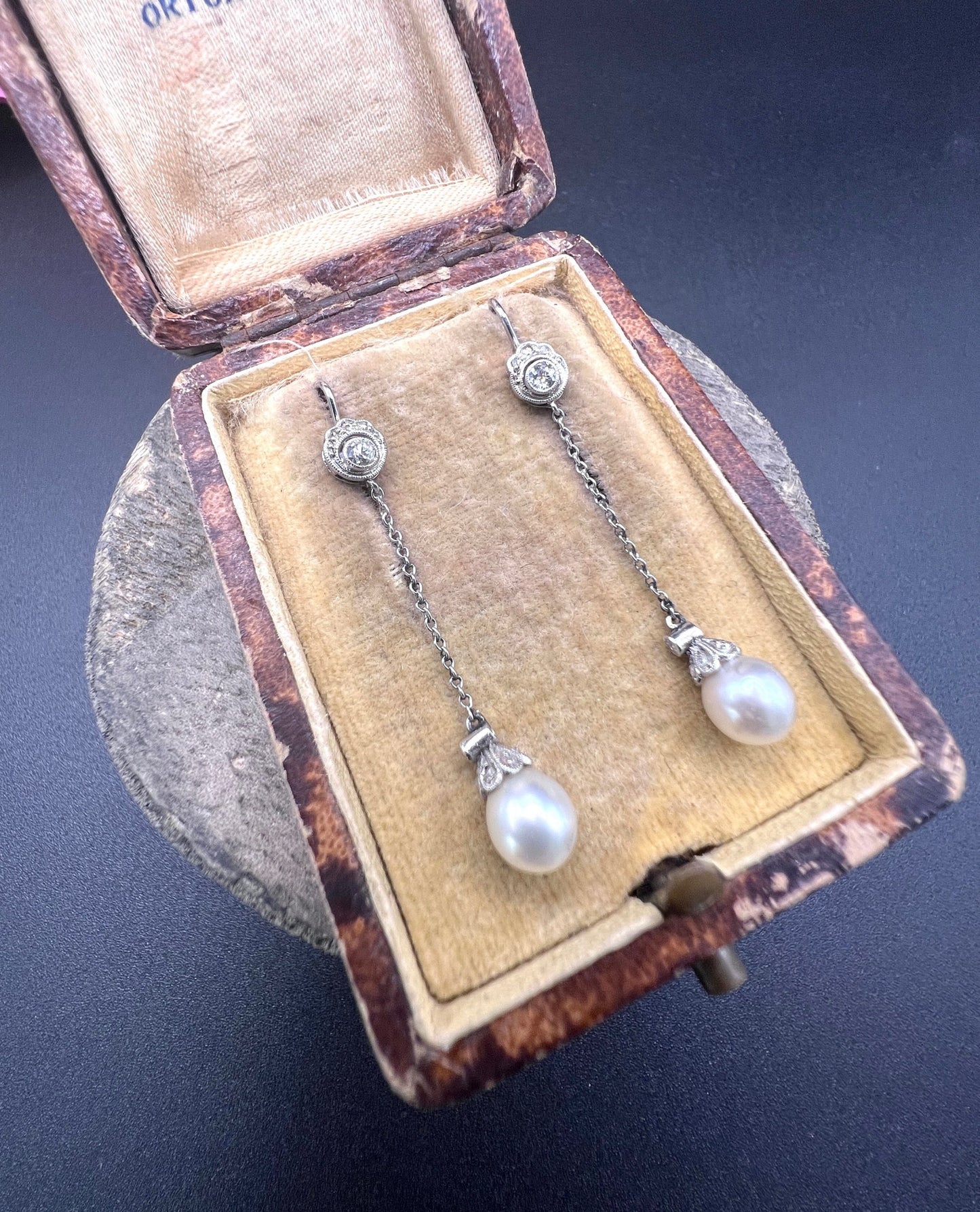 A pair of long drop platinum earrings with pearls and diamonds, in an antique box