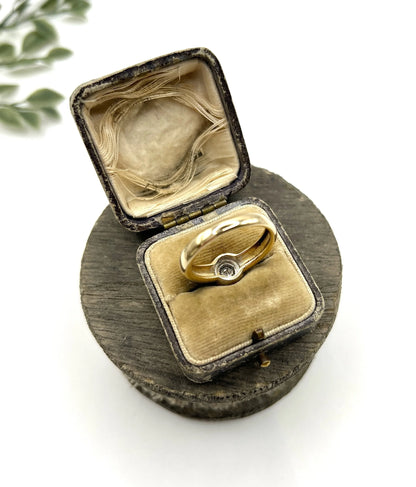 A single stone brilliant cut diamond ring bezel set in yellow gold, in a ring box