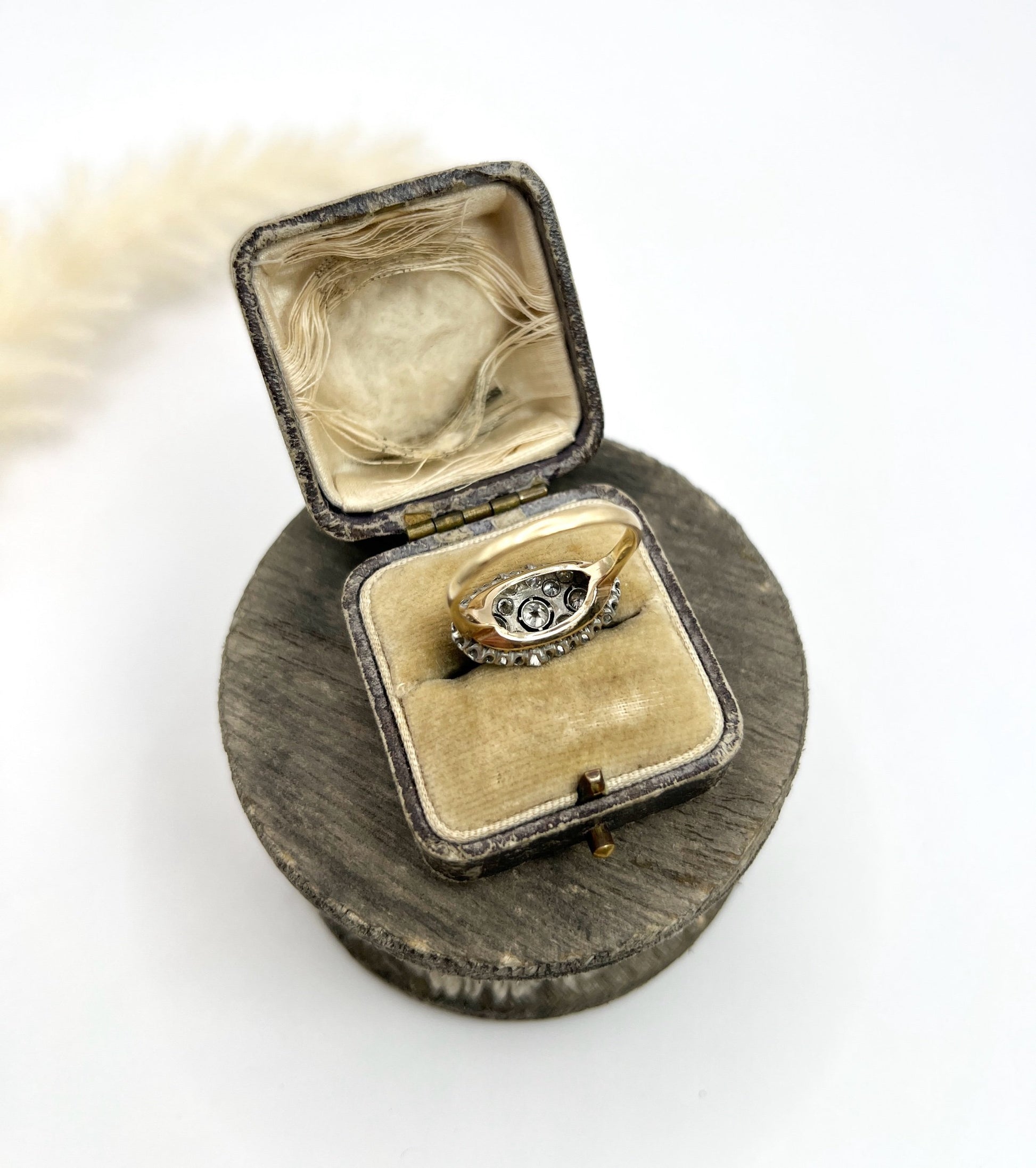 A diamond triple cluster ring in yellow and white gold, in a ring box