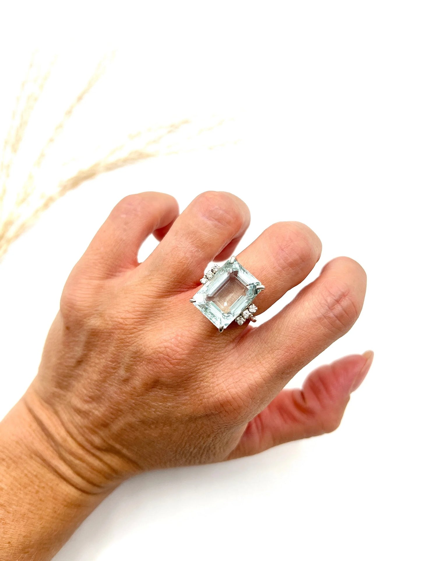 An aquamarine and diamond cocktail ring in white gold, modelled on a hand