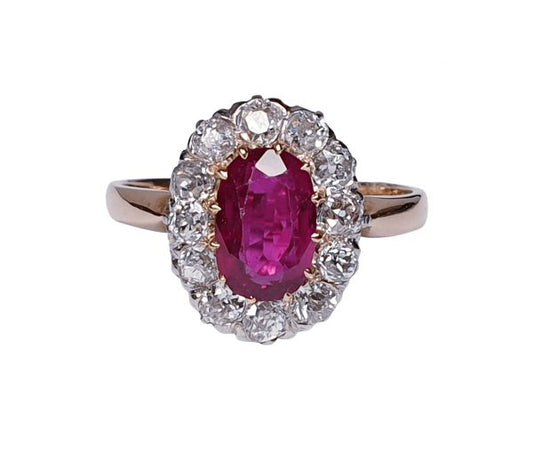 Antique Victorian Ruby and Diamond Oval Cluster Ring; featuring a 1.15 carat oval faceted ruby encompassed by 1.20cts sparkling diamonds, on a rose gold shank. English, Circa 1890