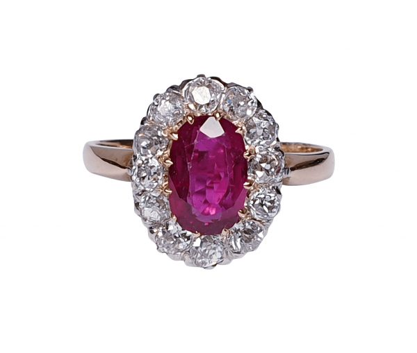 Antique Victorian Ruby and Diamond Oval Cluster Ring; featuring a 1.15 carat oval faceted ruby encompassed by 1.20cts sparkling diamonds, on a rose gold shank. English, Circa 1890