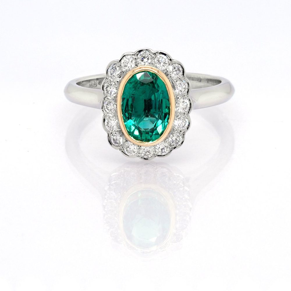 Emerald and diamond cluster ring in platinum.