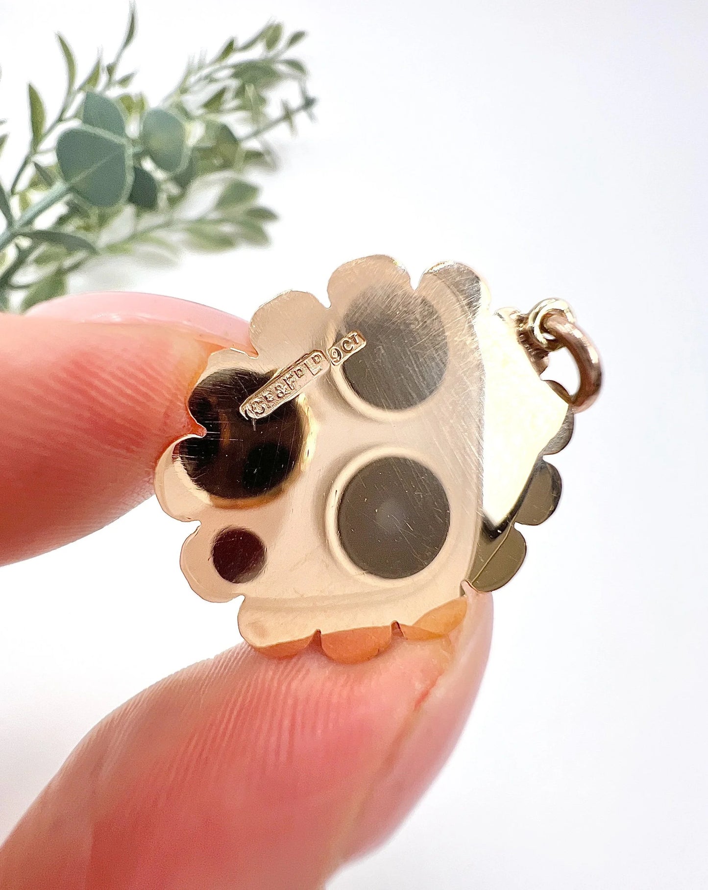 A cabochon garnet pendant with a seed pearl border in rose gold, with a 9CT stamp
