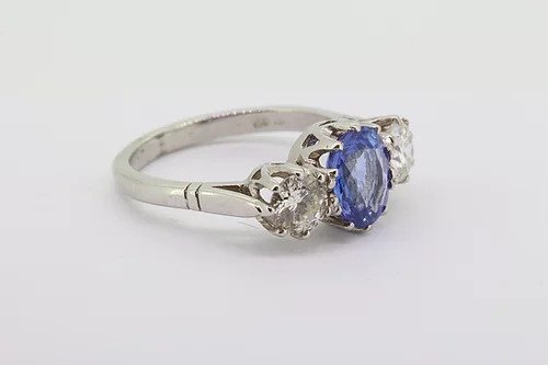 Sapphire and Diamond Three Stone Ring in Platinum; central 2.05 carat oval faceted sapphire flanked by 1.00cts round brilliant-cut diamonds