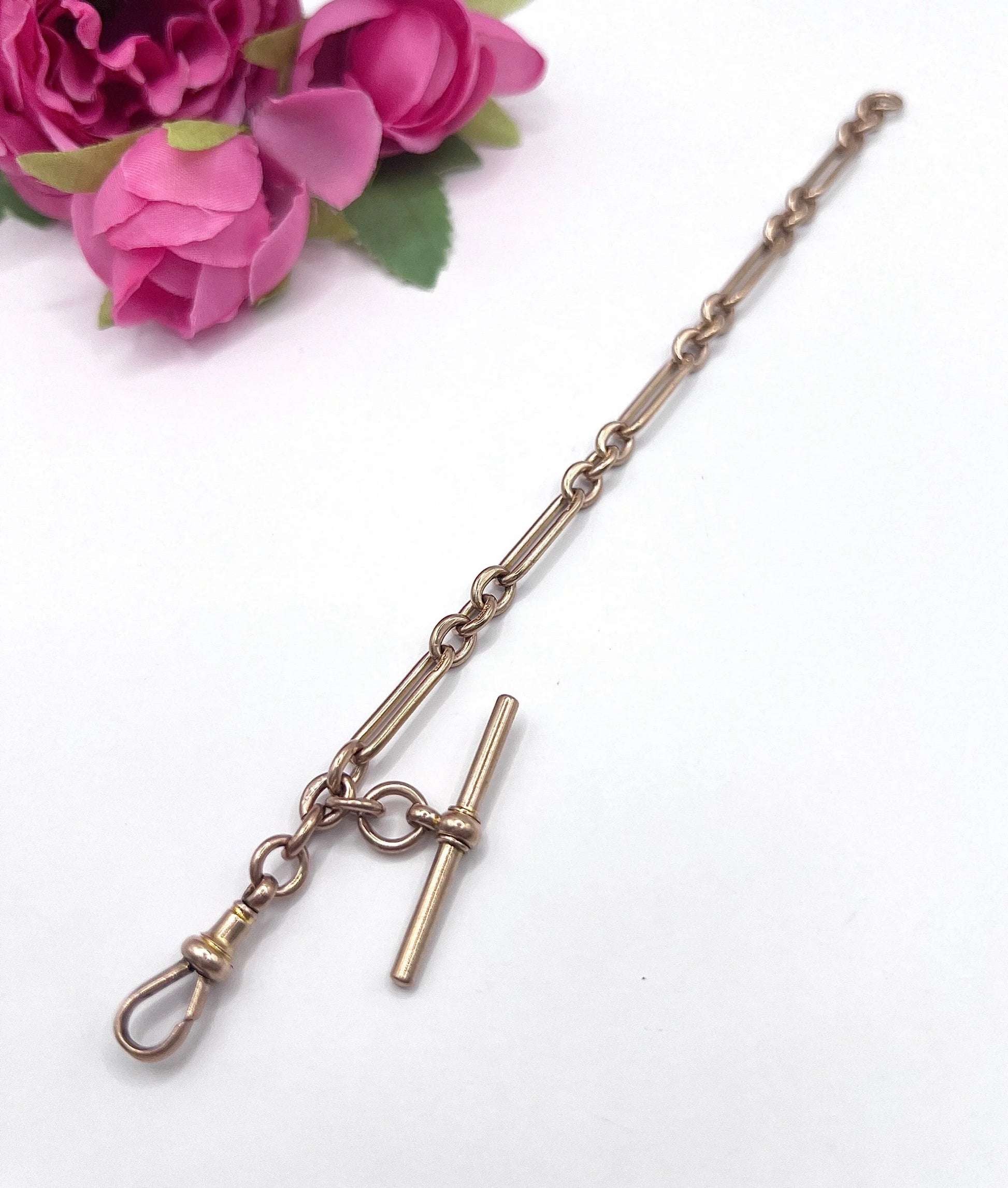 A rose gold link bracelet with a T-bar
