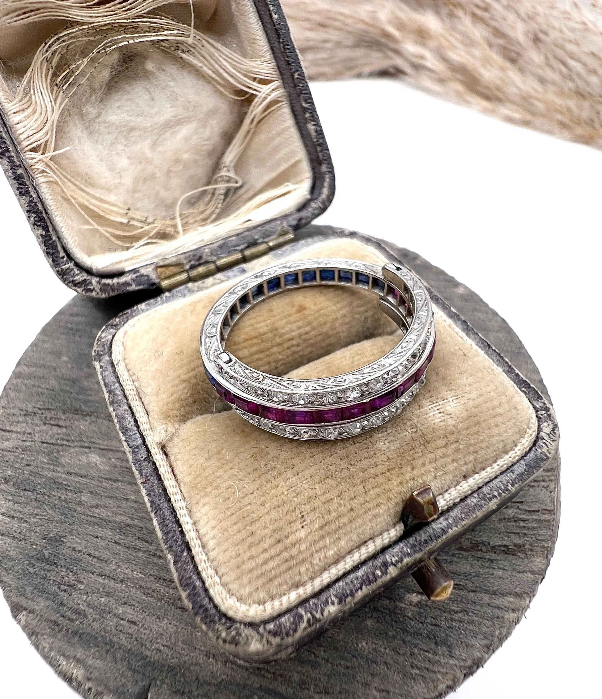 A platinum night and day flip band ring set with diamonds, sapphires and rubies, in a ring box