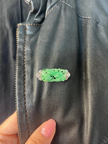 A carved green jade and diamond brooch in white gold, modelled on a black jacket