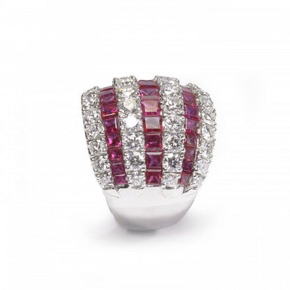 Contemporary Ruby and Diamond Bombe Cocktail Ring; seven alternating rows of 3.50cts calibre-cut rubies and 2.50cts round brilliant cut diamonds, claw and channel set in 18ct white gold, Circa 1990