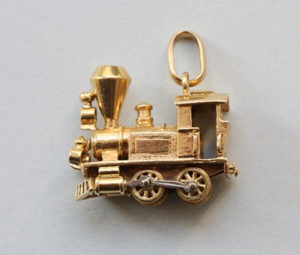 Vintage Van Cleef and Arpels 18ct Gold Locomotive Train Charm; with diamond and emerald set headlights, Signed and numbered, with Van Cleef & Arpels chain.