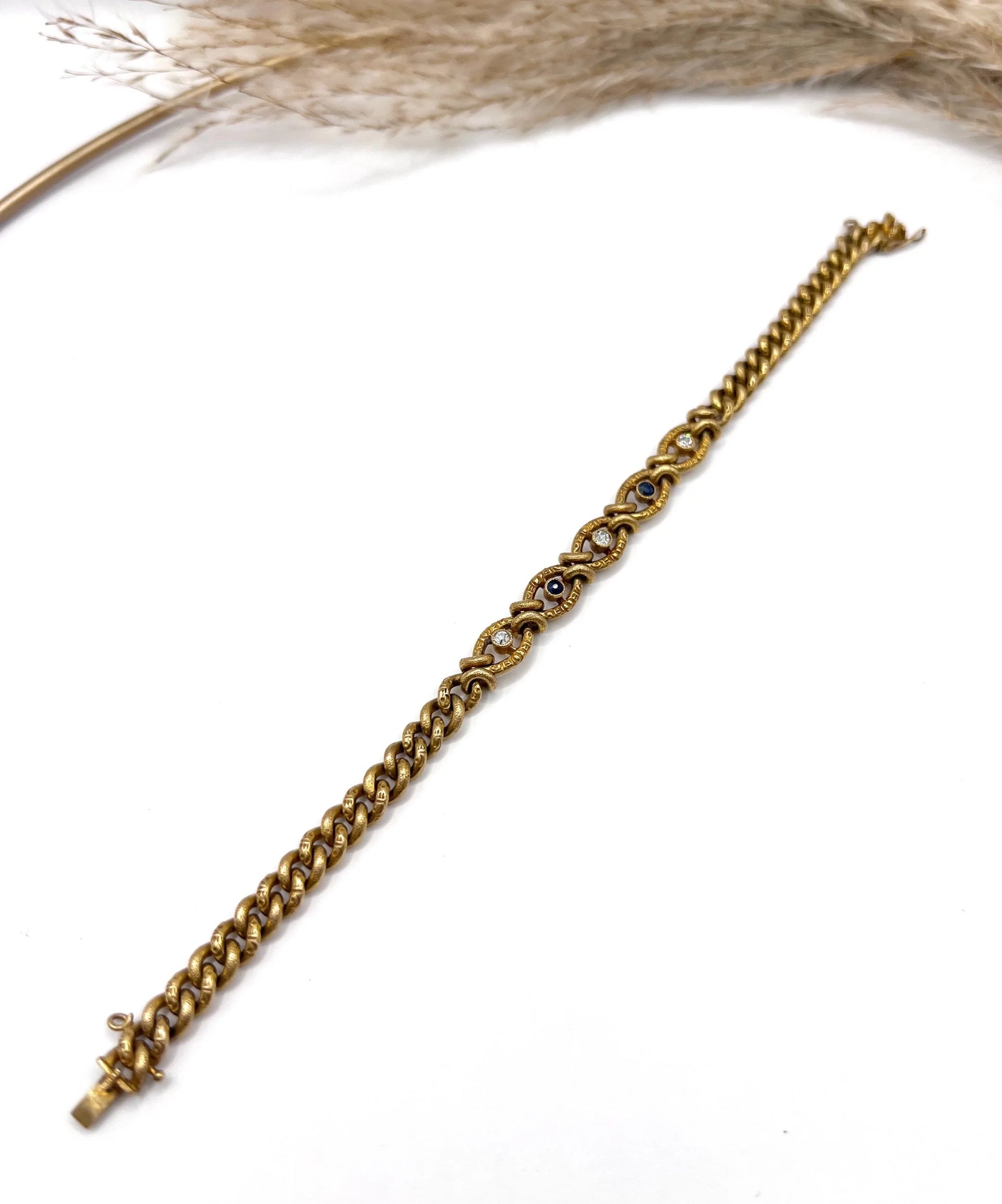 A sapphire and diamond fancy curb link bracelet in yellow gold
