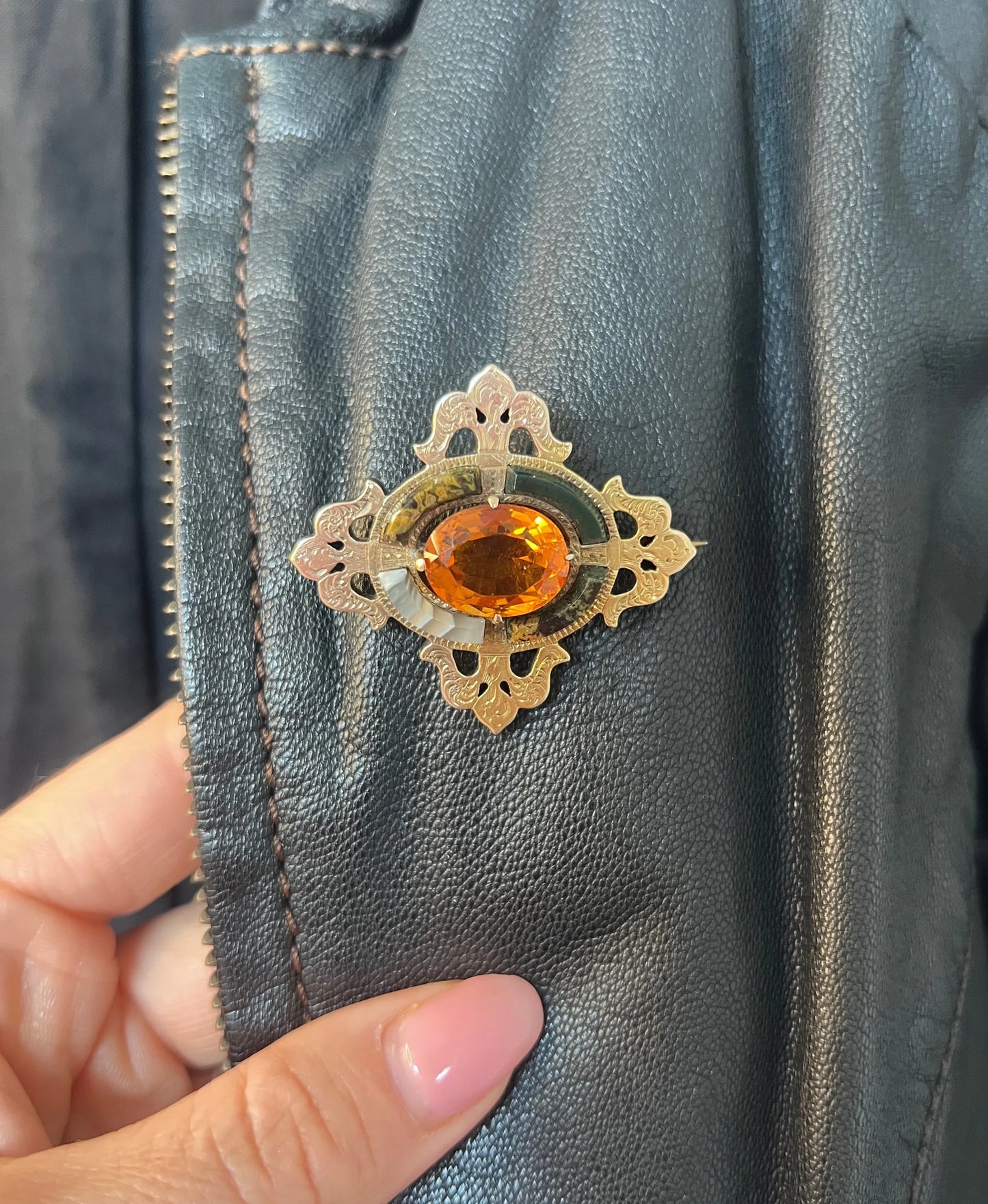 A yellow gold, oval citrine and agate ornate brooch, modelled on a black jacket