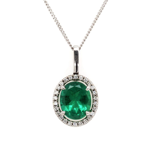 Emerald and diamond cluster pendant in white gold.