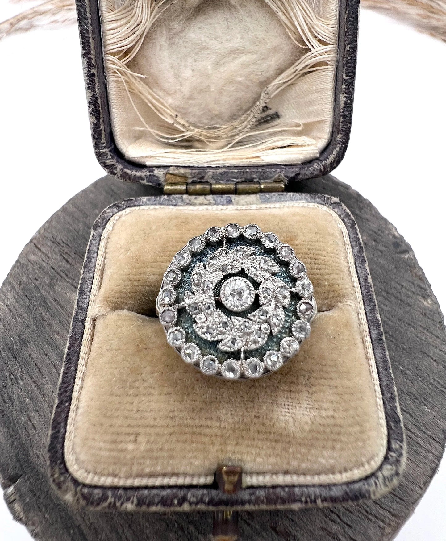 A diamond and dark blue enamel fancy cluster ring in white gold, in an antique ring box