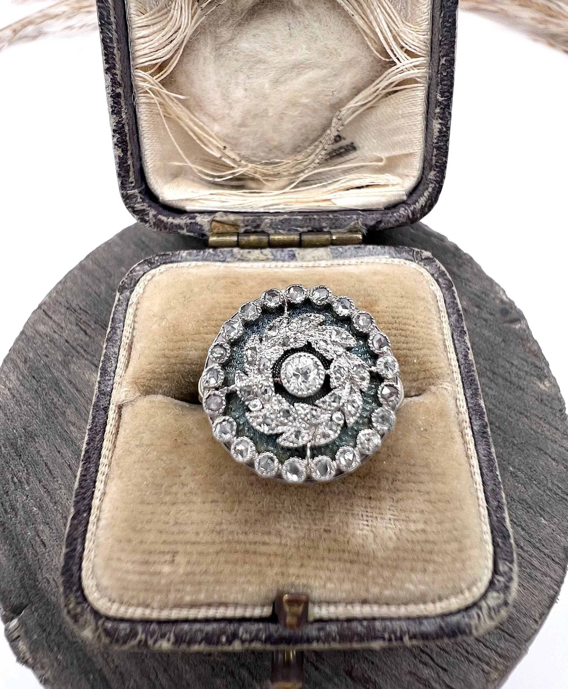 A diamond and dark blue enamel fancy cluster ring in white gold, in an antique ring box