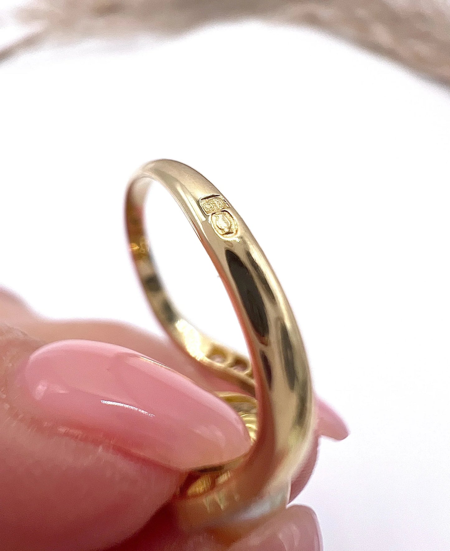 Close-up of French stamps on a yellow gold ring shank