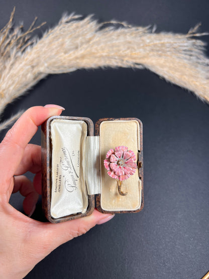 A pink enamelled flower brooch with a diamond centre, in yellow gold, in a box