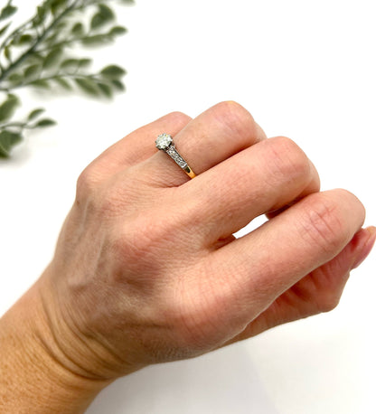 A diamond engagement style ring in yellow gold and platinum, modelled on a hand