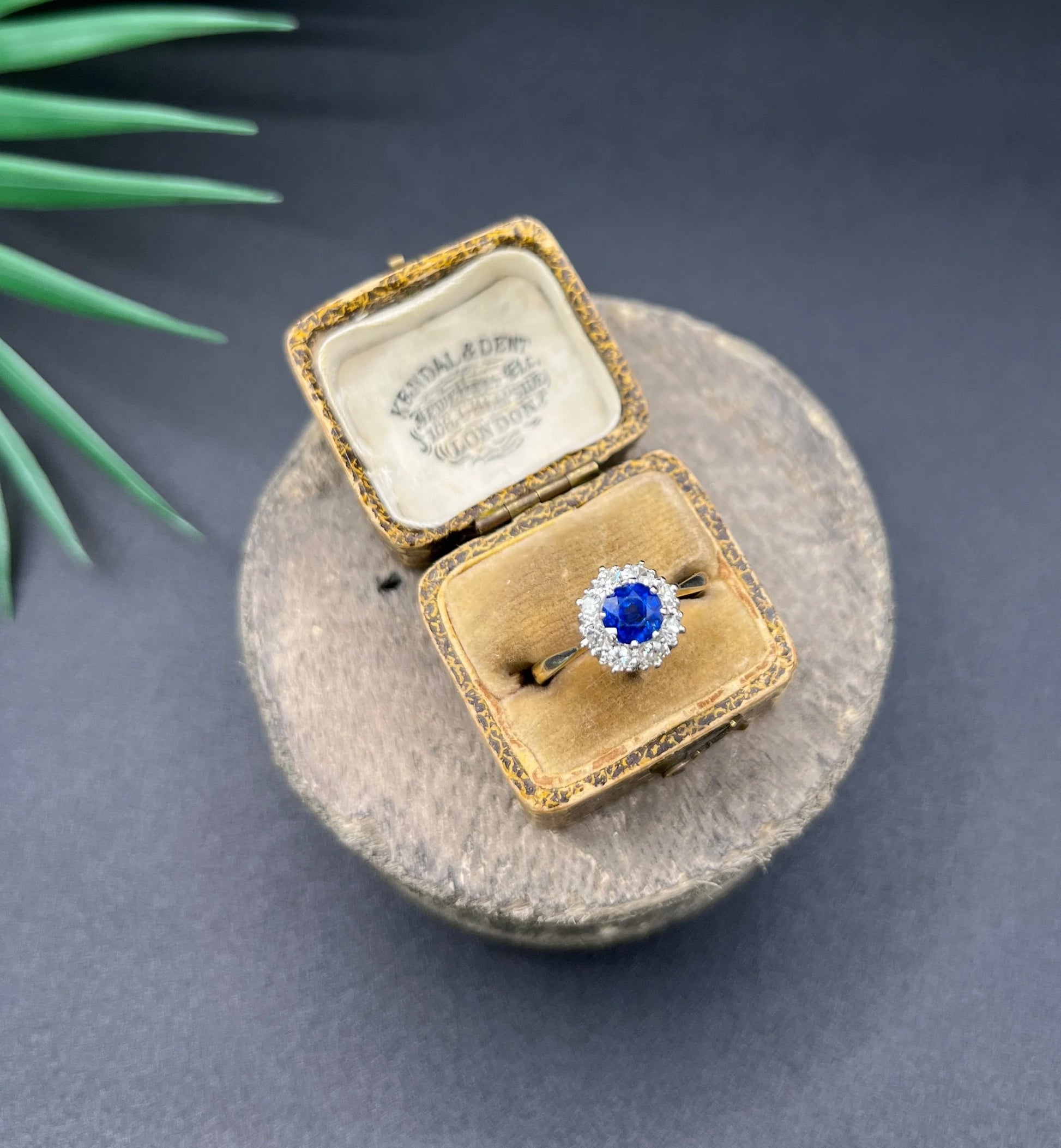 A circular cluster ring with sapphire and diamonds in yellow gold and platinum, in an antique ring box