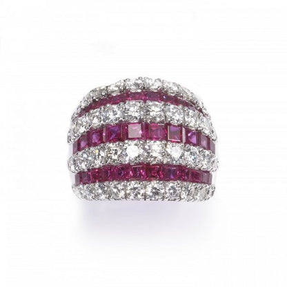 Contemporary Ruby and Diamond Bombe Cocktail Ring; seven alternating rows of 3.50cts calibre-cut rubies and 2.50cts round brilliant cut diamonds, claw and channel set in 18ct white gold, Circa 1990