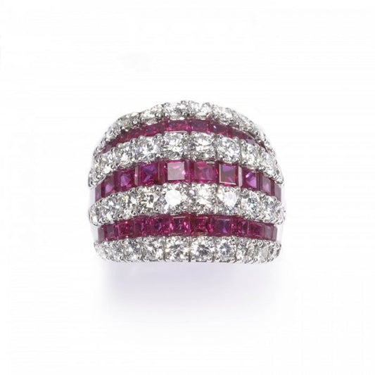 Contemporary Ruby and Diamond Bombe Cocktail Ring; seven alternating rows of 3.50cts calibre-cut rubies and 2.50cts round brilliant cut diamonds, claw and channel set in 18ct white gold, Circa 1990