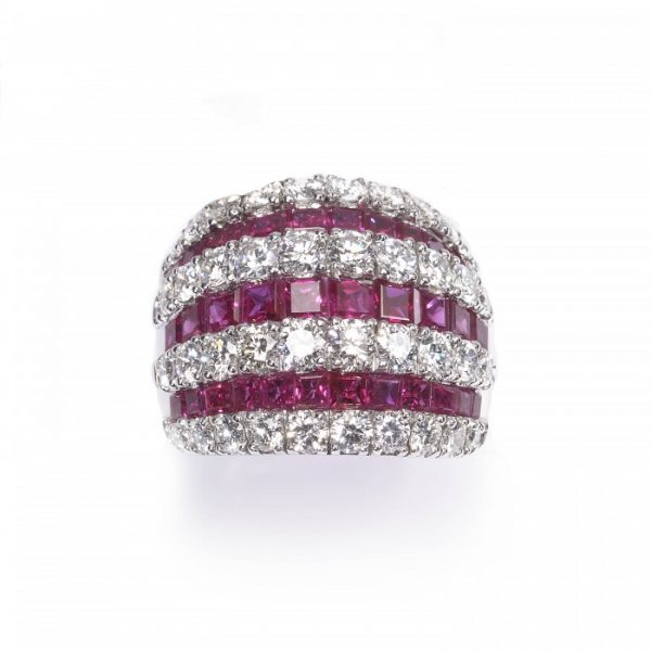 Contemporary Ruby and Diamond Bombe Cocktail Ring; seven alternating rows of 3.50cts calibre-cut rubies and 2.50cts round brilliant cut diamonds, claw and channel set in 18ct white gold, Circa 1990