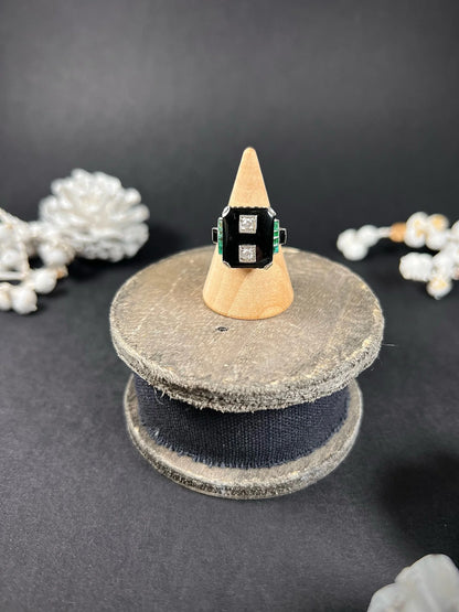 A geometric black onyx ring with diamonds and emeralds in white gold, on a ring cone