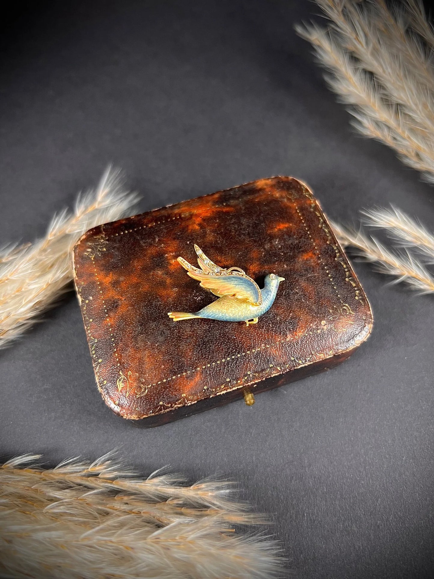 An enamel and diamond dove bird pendant, on an antique box